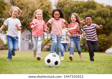Group Of Children Playing Football With Friends In Park Royalty-Free Stock Photo #1447101812