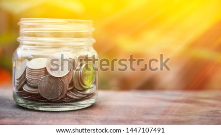 Thai Baht Coins Money in Jar on Wooden Table