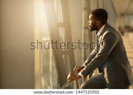 Wait for Plane. African-American Businessman Looking Through Window in Airport, Copy Space Royalty-Free Stock Photo #1447125902