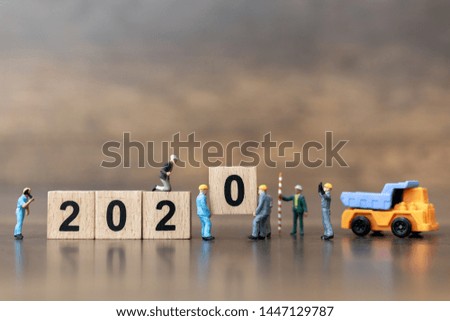 Miniature people : Worker team create wooden block number 2020  , Happy new year concept