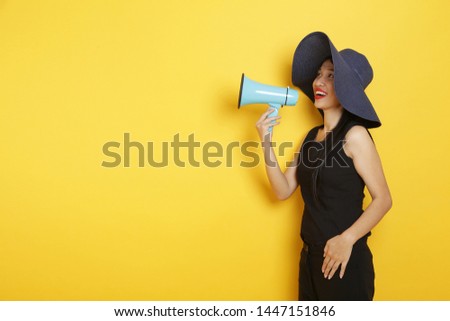 Beauty young attractive mix-race asian women shout out through megaphone with big bright yellow colour background
