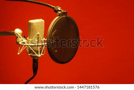 Microphone in a recording studio.Red background microphone In a professional recording room.