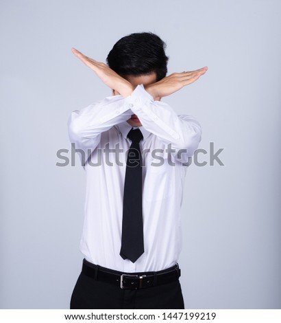 Portrait handsome young asian 
businessman wearing a white shirt doing no or stop sign isolated on grey background in studio. Asian man people. business success concept.