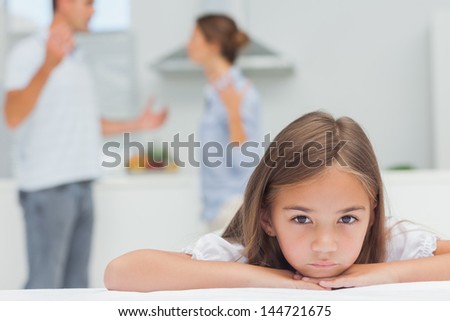 Upset girl listening to parents quarreling in the kitchen Royalty-Free Stock Photo #144721675