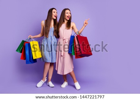 Full length body size photo two people beautiful she her models chic ladies carry many packs direct empty space laugh laughter fellowship wear casual dresses isolated purple violet bright background Royalty-Free Stock Photo #1447221797