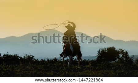 Silhouette Cowboy on horseback.Cowboy riding horse at sunset or sunrise time.