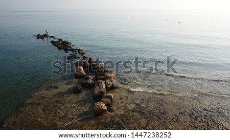 a path made of stones that stay above the surface of deep water,  in a sunny day