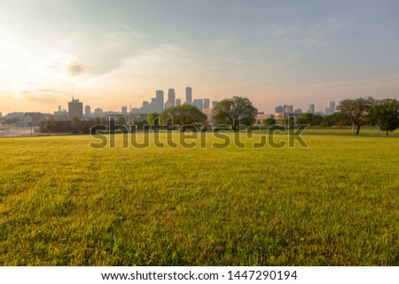 Downtown Minneapolis on a foggy morning with grass in the foreground.