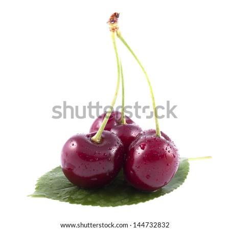 Three cherries with green leaf on a white background