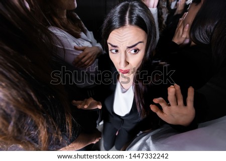 overhead view of businesswoman suffering from claustrophobia in crowded elevator