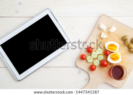 tablet,tea and Turkish,Mediterranean Breakfast before the start of the working day or while working on a light wooden tray on a white natural background. the view from the top