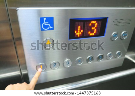Hand pressing the disabled elevator button of the elevator. Soft focus. Sign and technology concept.