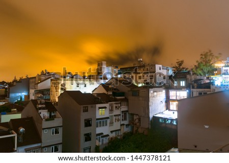 Long exposure landscape photo shot of the beautiful and mesmerizing orange nigh sky over the city after a heavy rain. Picture taken in an urban neighbourhood of Dalat, Lam Dong, Vietnam