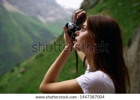 woman takes pictures of nature on camera mountains