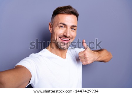 Close up photo amazing positive he him his middle age macho perfect appearance easy-going make take selfies hand arm thumb up symbol toothy mouth wear casual white t-shirt isolated grey background
