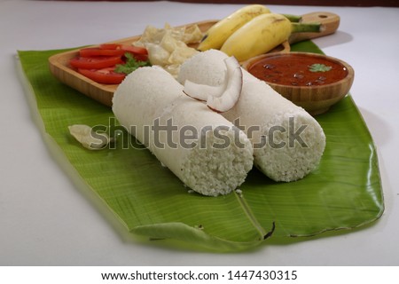 white rice puttu with kadala curry-two slices white rice puttu with kadala/ bengal gram curry,paappad and banana as side dish south indian specialy kerala special food placed on a banana leaf