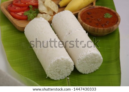 white rice puttu with kadala curry-two slices white rice puttu with kadala/ bengal gram curry,paappad and banana as side dish south indian specialy kerala special food placed on a banana leaf