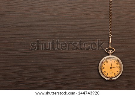 Photo of silver vintage pocket watch with chain on wooden background