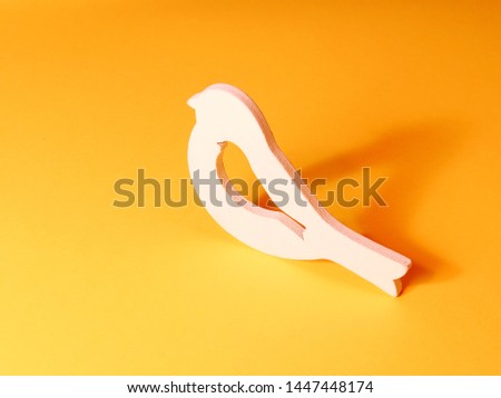 White wooden bird on a yellow background
