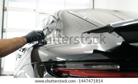 Staff wear Chemical protective clothing at work. Automobile industry. Car wash and coating business with ceramic coating.Spraying the varnish to the car. Concept of: Car protective, Service, Shine. Royalty-Free Stock Photo #1447471814