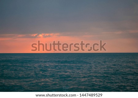 a beautiful sunrise at sea. Boat and rocks near the shore. swans in flight
