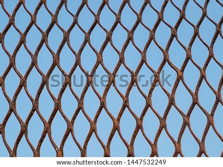 Metal grid on a background of blue sky as a background for design