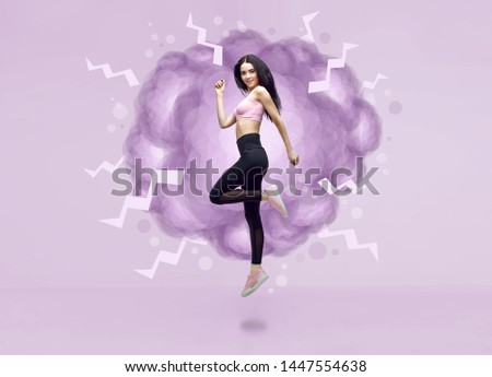 Amazing woman in trendy sportswear jumping. Smiling beautiful slim brunette young girl in fashion leggings and pink top expressing happy emotions. Purple background.