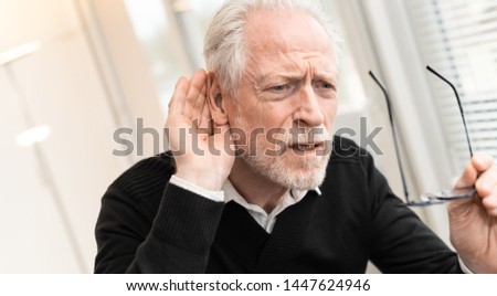 Portrait of senior man having hearing problems Royalty-Free Stock Photo #1447624946