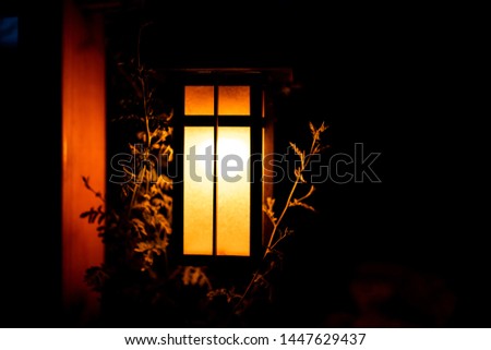 Japan in evening dark night with lantern illuminated lamp light in garden with golden yellow illumination color