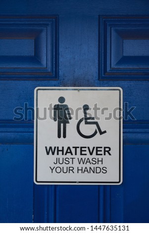 Sign on a blue restroom door says "Whatever Just Wash Your Hands" and includes male, female, and handicapped symbols