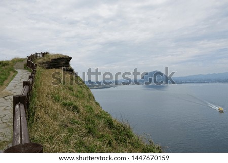 walkway on seaside cliff, against cloudy sky