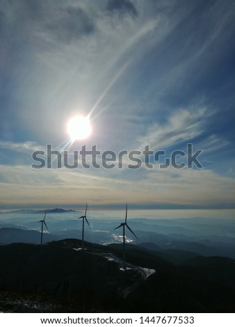 The wonderful view of the wind turbine that converts wind into energy is in harmony with the blue sky