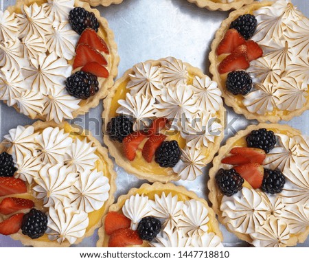 Lemon tarts with strawberries, blackberries and meringue