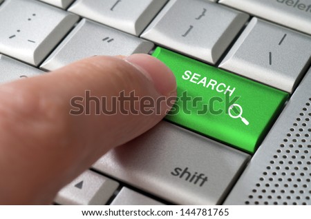 Business concept male finger pointing search key on  a metallic keyboard