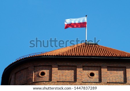 Polish national flag on the top of roof Wawel tower. White with red colors flag is main symbol of Poland state.