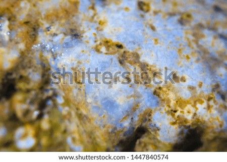 Blurred texture of a wet surface of colorful stone photographed in macro mode with a shallow depth of field effect.