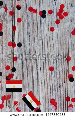 National day of Egypt on 23 July. revolution day. the concept of veterans Day or memorial Day . Egypt glory to the heroes of the war. mini flags and confetti on white wooden background. vertical