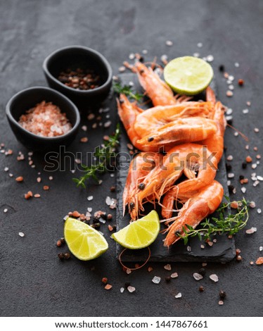 Shrimps served with lemons and spices on a black background