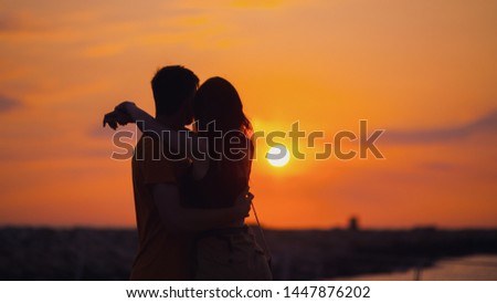 Couple hug during morning sunrise at sea shore