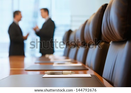Side view of two blurred businessmen talking in conference room Royalty-Free Stock Photo #144792676