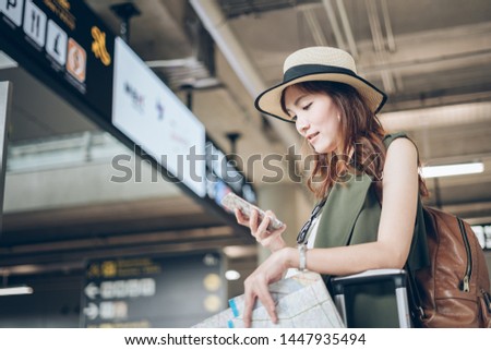 Passport checking online on phone - Travelers Asian woman flight schedules on a mobile phone in the airport preparing to board the plane Royalty-Free Stock Photo #1447935494