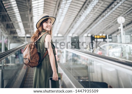 Journey at Airport Terminal  , Asian woman traveler walking dragging a suitcase to gate in airport Royalty-Free Stock Photo #1447935509