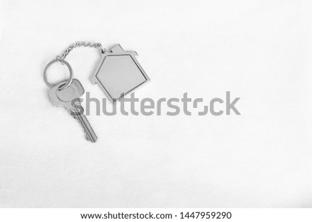 House key with home keyring in on white background, real estate concept, copy space