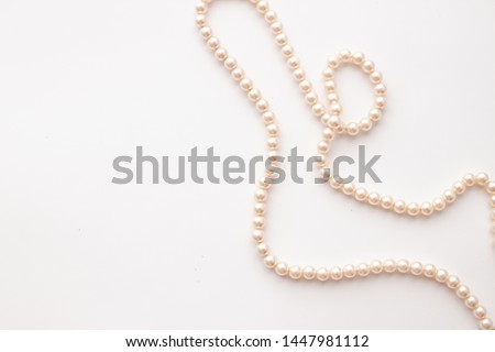 Pearls on white background with copy space. Necklace jewelry. Royalty-Free Stock Photo #1447981112