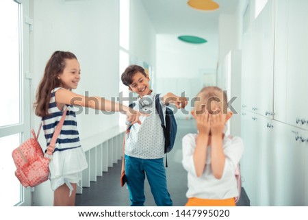 Suffering from bullying. Little blonde-haired girl suffering from bullying during school break
