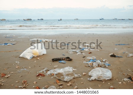 Trash, plastic, garbage, bottle, bag ... environmental pollution on the sandy beach. Royalty high-quality stock photo image of trash, plastic bag on sand beach. Waste that polluted ocean environment