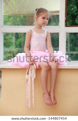 Beautiful dancer in a pink leotard has been training in ballet class