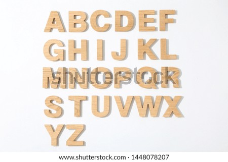 Wooden letters of English alphabet on white background, top view