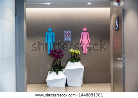 View to entrance restroom of international airport. Pink and blue symbol of men and women. No Smoking sign. Separate room for disabled people. The convenience of a modern international air terminal