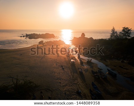 Aerial vie of strong shadows by fisherman's boats that are on the beach at sunrise